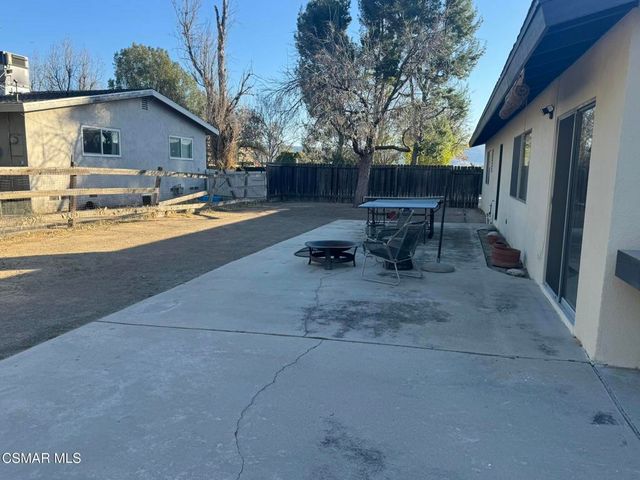 a view of a patio with table and chairs and potted plants