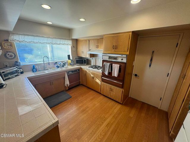 a kitchen with sink refrigerator and microwave
