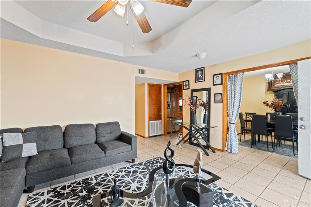 106 Rosa Priego Street Donna, TX 78537 - Photo 4 of 25 Tiled living room with ceiling fan and a tray ceiling