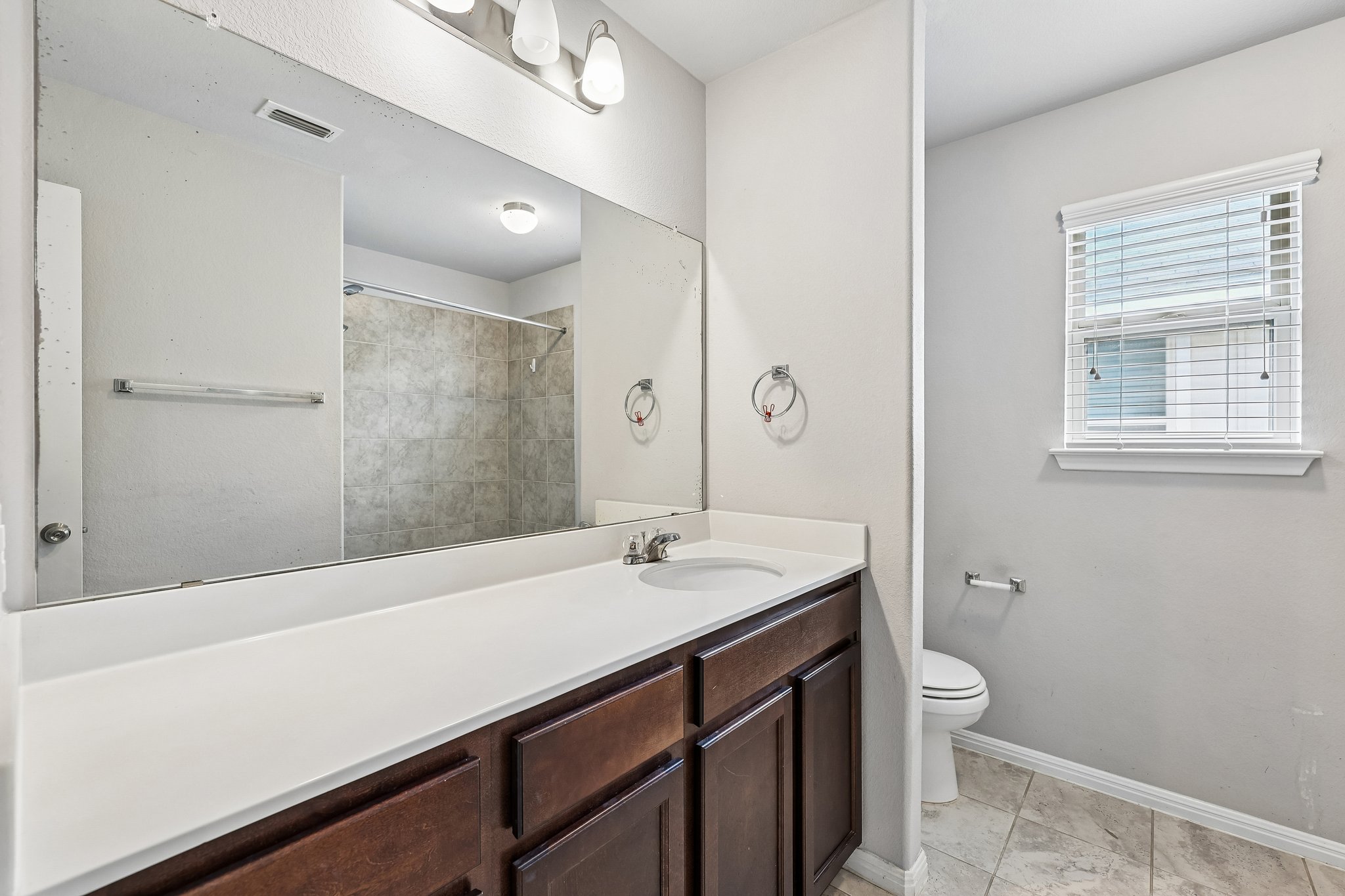 387 Guemal Road Buda, TX 78610 - Photo 22 of 39 Spacious bathroom featuring an extended vanity with dark wood-finish cabinetry and a single integrated sink