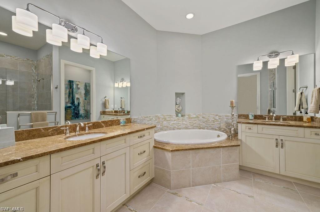 6565 Roma Way Naples, FL 34113 - Photo 11 of 32 a bathroom with a sink and a mirror