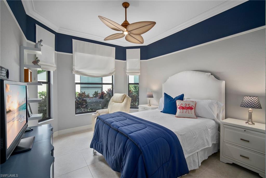 6565 Roma Way Naples, FL 34113 - Photo 13 of 32 a bedroom with a large bed and a chandelier