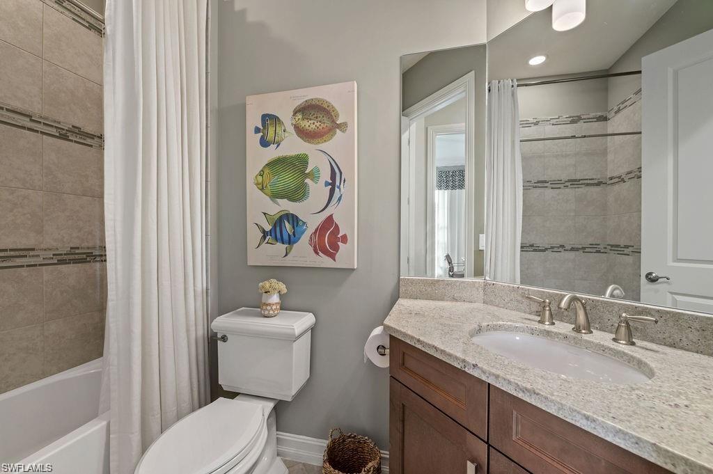 6565 Roma Way Naples, FL 34113 - Photo 14 of 32 a bathroom with a granite countertop sink mirror vanity and toilet
