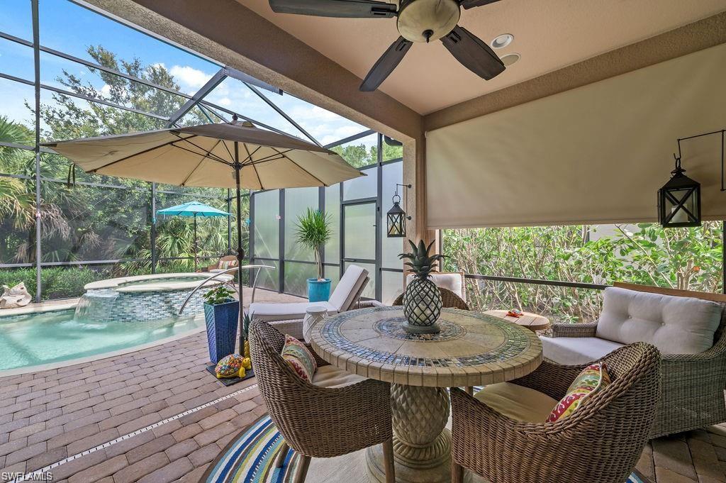 6565 Roma Way Naples, FL 34113 - Photo 19 of 32 a view of balcony with furniture and umbrella