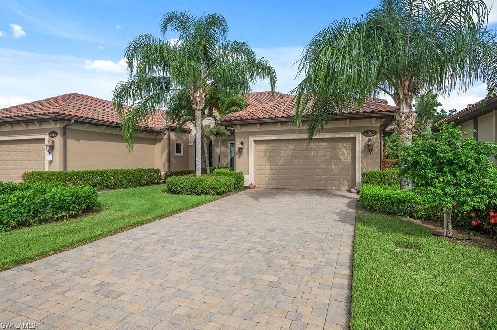 6565 Roma Way Naples, FL 34113 - Photo 2 of 32 a front view of a house with a garden and palm trees