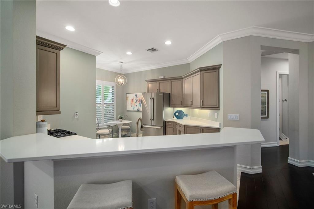 6565 Roma Way Naples, FL 34113 - Photo 3 of 32 a kitchen with a sink and chairs