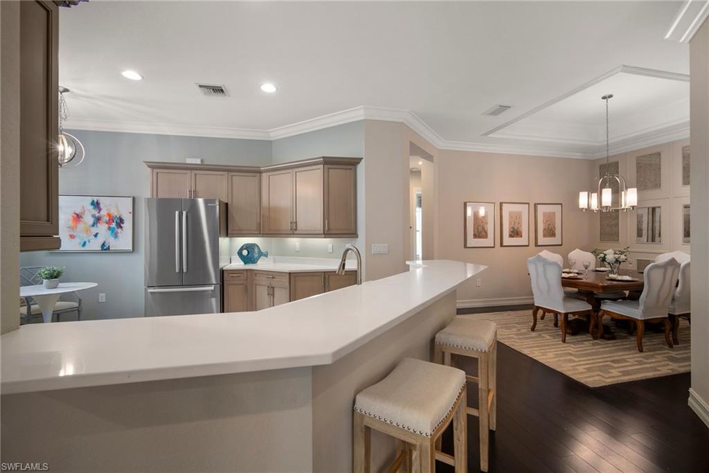 6565 Roma Way Naples, FL 34113 - Photo 5 of 32 a large kitchen with a table and chairs