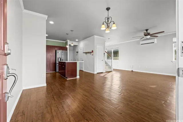 a view of a room with wooden floor staircase and a kitchen