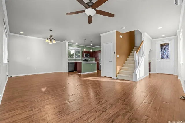 a view of empty room with wooden floor and ceiling fan