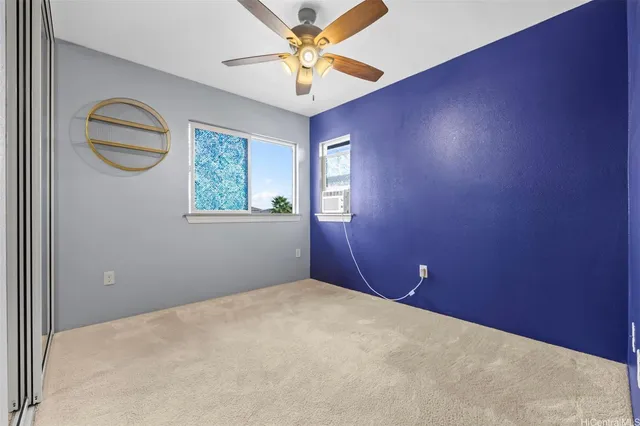 an empty room with windows and fan