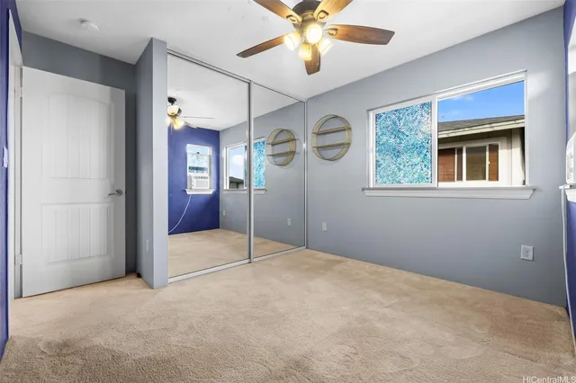 a view of an empty room with a chandelier fan