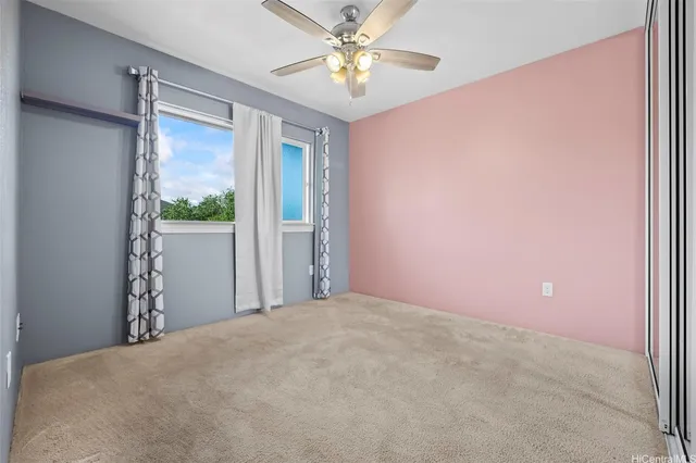 a view of a bedroom with a ceiling fan and a window