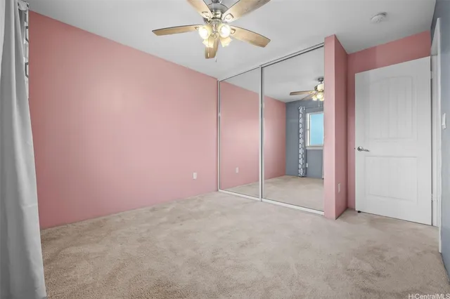 a view of a big room with closet and a chandelier fan