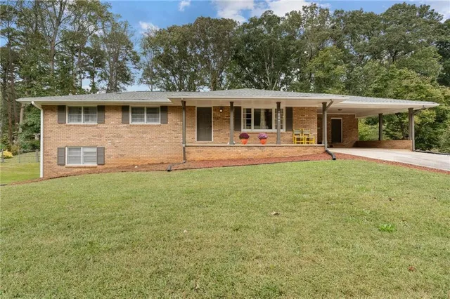 a front view of house with yard and trees in the background