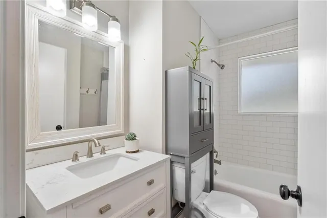 a bathroom with a granite countertop sink toilet a shower and a mirror