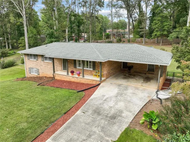 a view of a house with a yard potted plants and large tree
