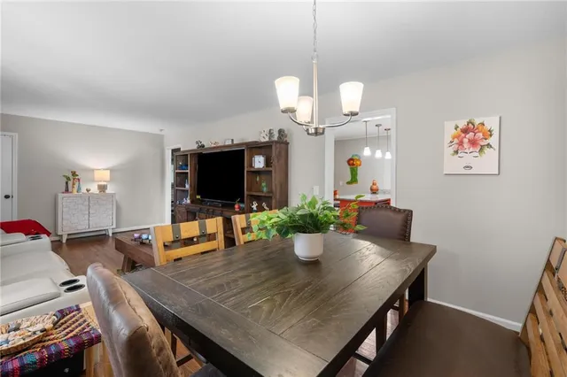 a view of a dining room with furniture a chandelier and wooden floor