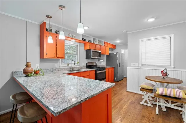 a kitchen with stainless steel appliances granite countertop a sink table and chairs in it
