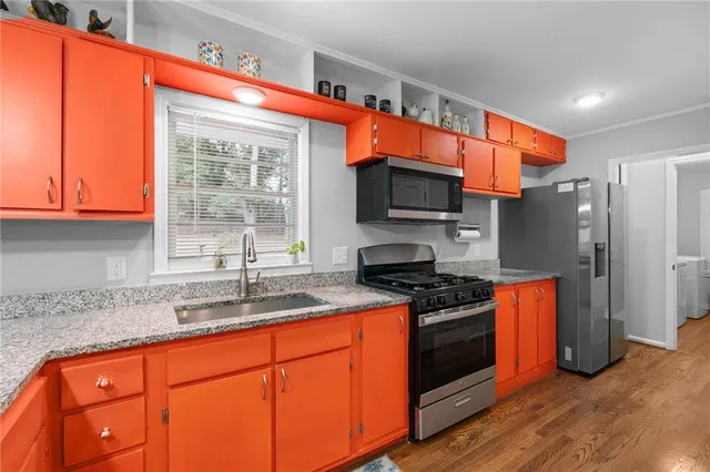 a kitchen with stainless steel appliances granite countertop a stove a sink and a refrigerator