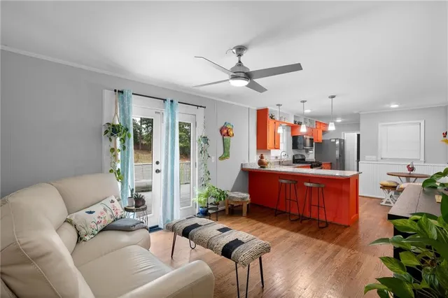 a living room with furniture kitchen area and a chandelier
