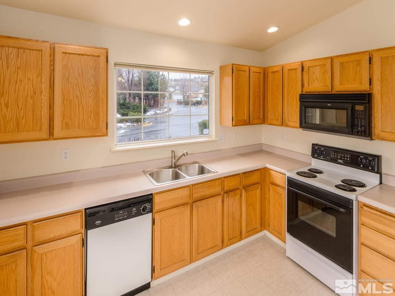 4775 Goodwin Road Sparks, NV 89436 - Photo 3 of 19 a kitchen with stainless steel appliances granite countertop a sink stove and microwave