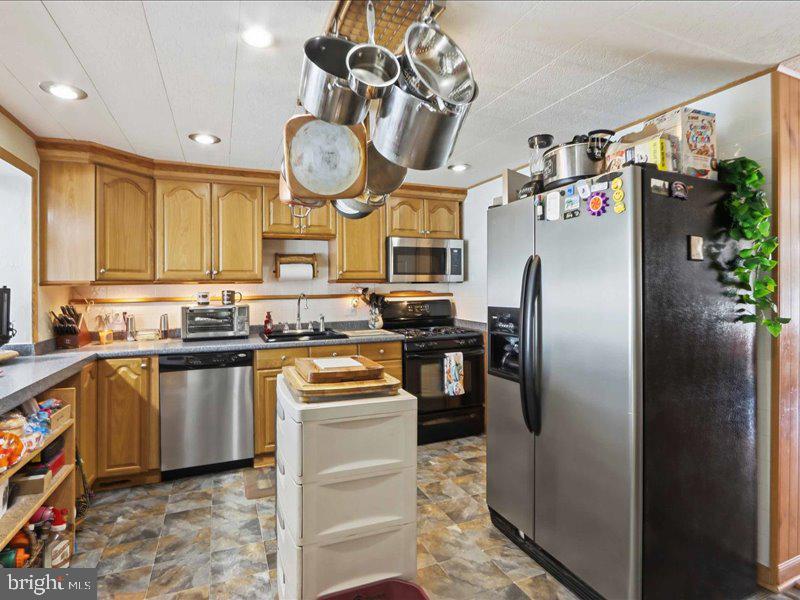 4344 Annapolis Road Halethorpe, MD 21227 - Photo 13 of 35 a kitchen with stainless steel appliances granite countertop a sink a stove and a refrigerator