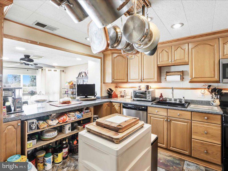 4344 Annapolis Road Halethorpe, MD 21227 - Photo 14 of 35 a kitchen with kitchen island granite countertop a sink a stove and cabinets