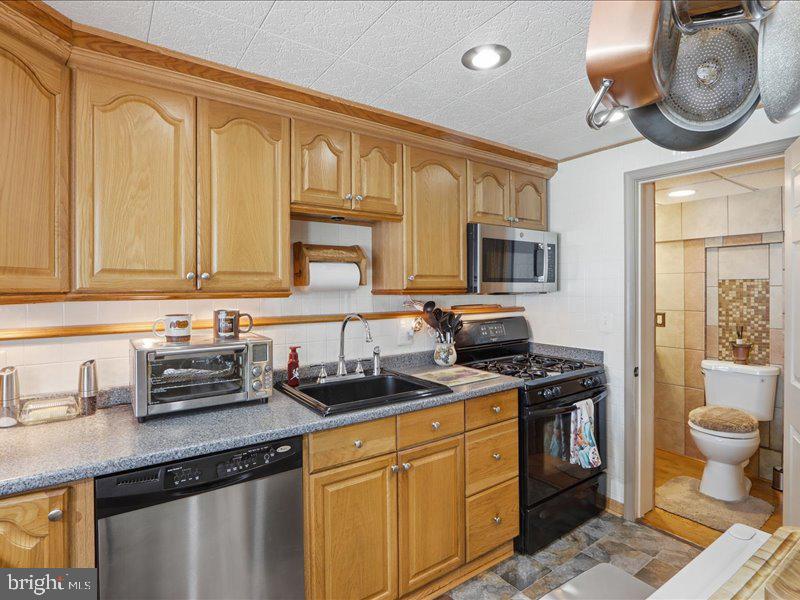 4344 Annapolis Road Halethorpe, MD 21227 - Photo 17 of 35 a kitchen with stainless steel appliances granite countertop a sink stove and cabinets