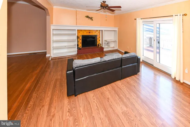 a living room with a bed and wooden floor