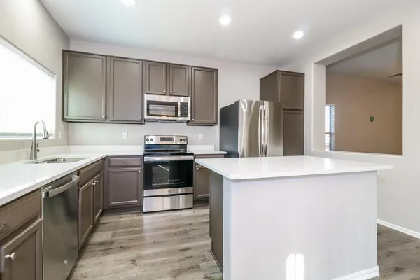 a kitchen with kitchen island stainless steel appliances a sink stove and refrigerator
