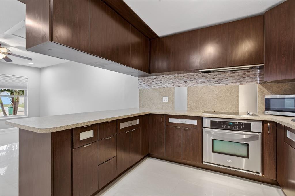 8709 Northwest 57th Drive Tamarac, FL 33321 - Photo 16 of 34 a kitchen with granite countertop stainless steel appliances and white cabinets