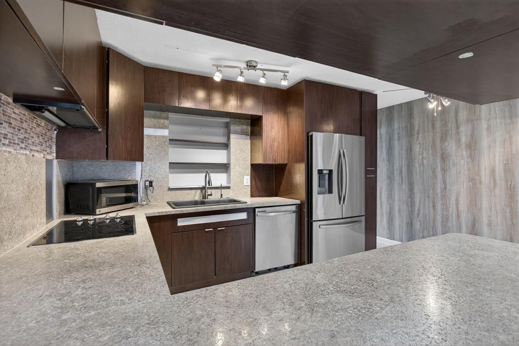 8709 Northwest 57th Drive Tamarac, FL 33321 - Photo 18 of 34 a kitchen with stainless steel appliances granite countertop a refrigerator and a stove top oven