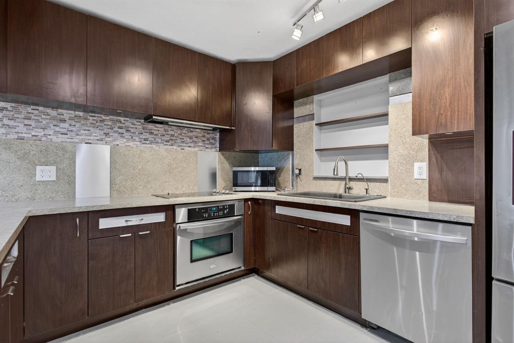 8709 Northwest 57th Drive Tamarac, FL 33321 - Photo 2 of 34 a kitchen with stainless steel appliances granite countertop a sink stove and cabinets