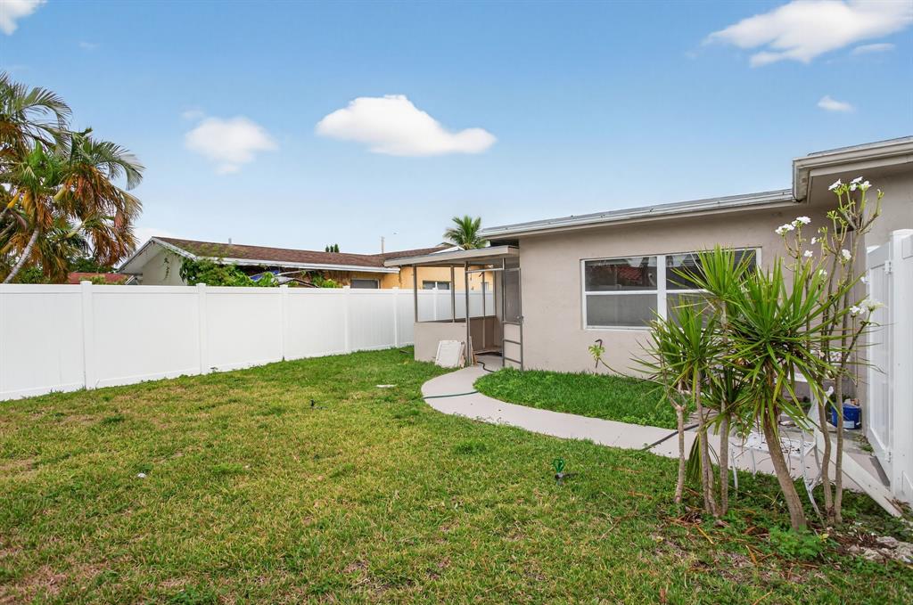 8709 Northwest 57th Drive Tamarac, FL 33321 - Photo 22 of 34 a view of a backyard with plants and palm trees