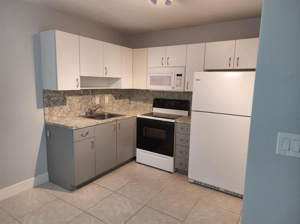 8709 Northwest 57th Drive Tamarac, FL 33321 - Photo 29 of 34 a kitchen with cabinets stainless steel appliances and a sink