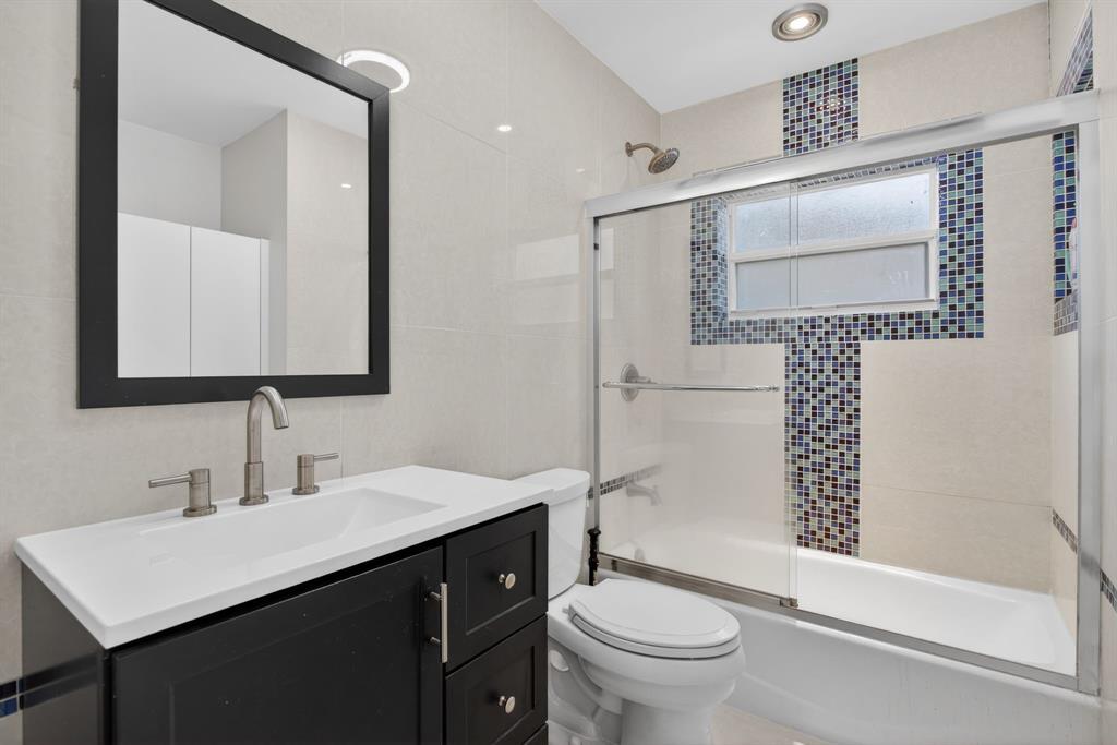 8709 Northwest 57th Drive Tamarac, FL 33321 - Photo 4 of 34 a bathroom with a sink a toilet and shower