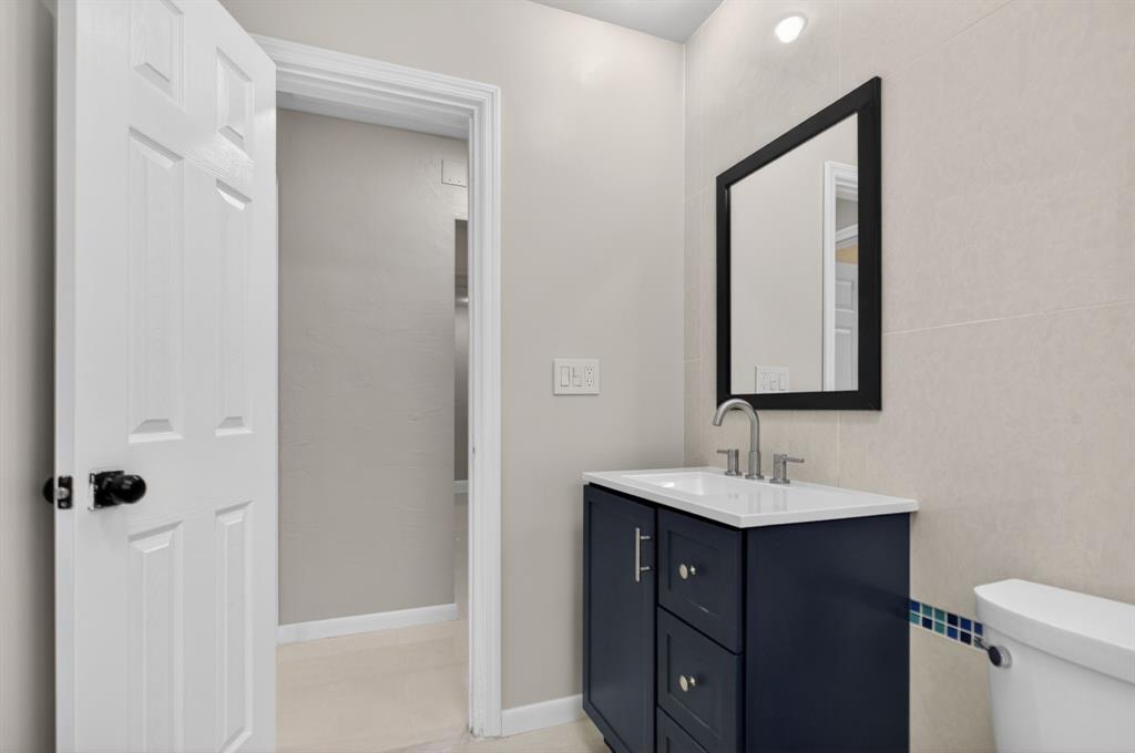 8709 Northwest 57th Drive Tamarac, FL 33321 - Photo 5 of 34 a bathroom with a toilet sink vanity and mirror