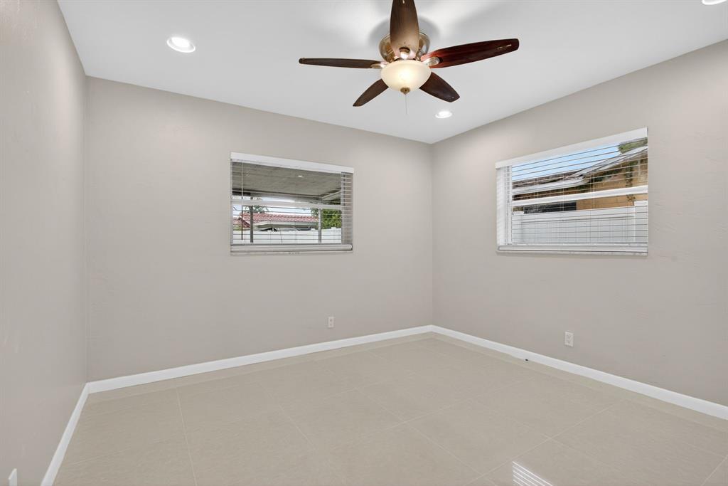 8709 Northwest 57th Drive Tamarac, FL 33321 - Photo 6 of 34 en empty room with windows and ceiling fan