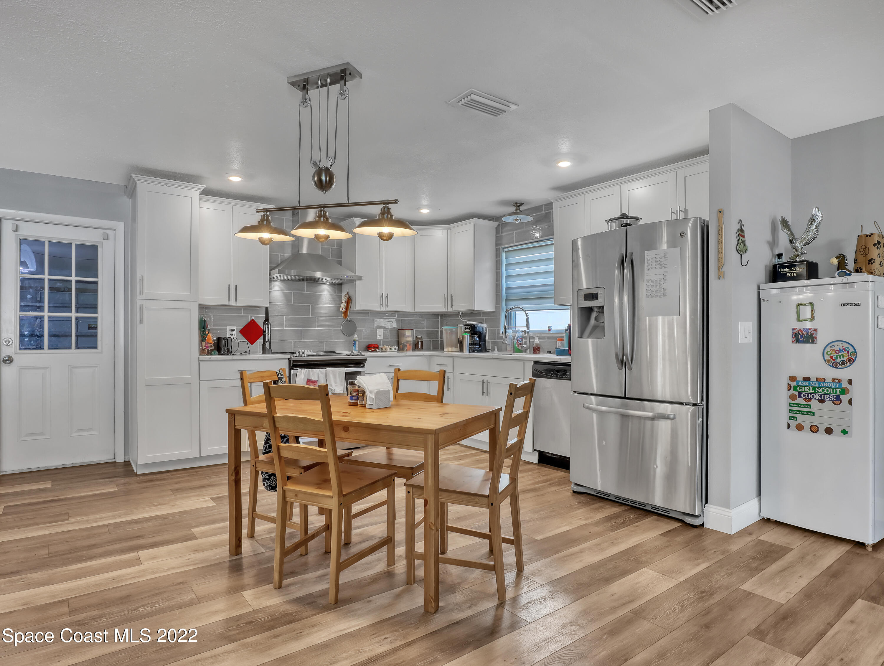 765 New Hampton Way Merritt Island, FL 32953 - Photo 10 of 37 a kitchen with stainless steel appliances a dining table chairs refrigerator and sink