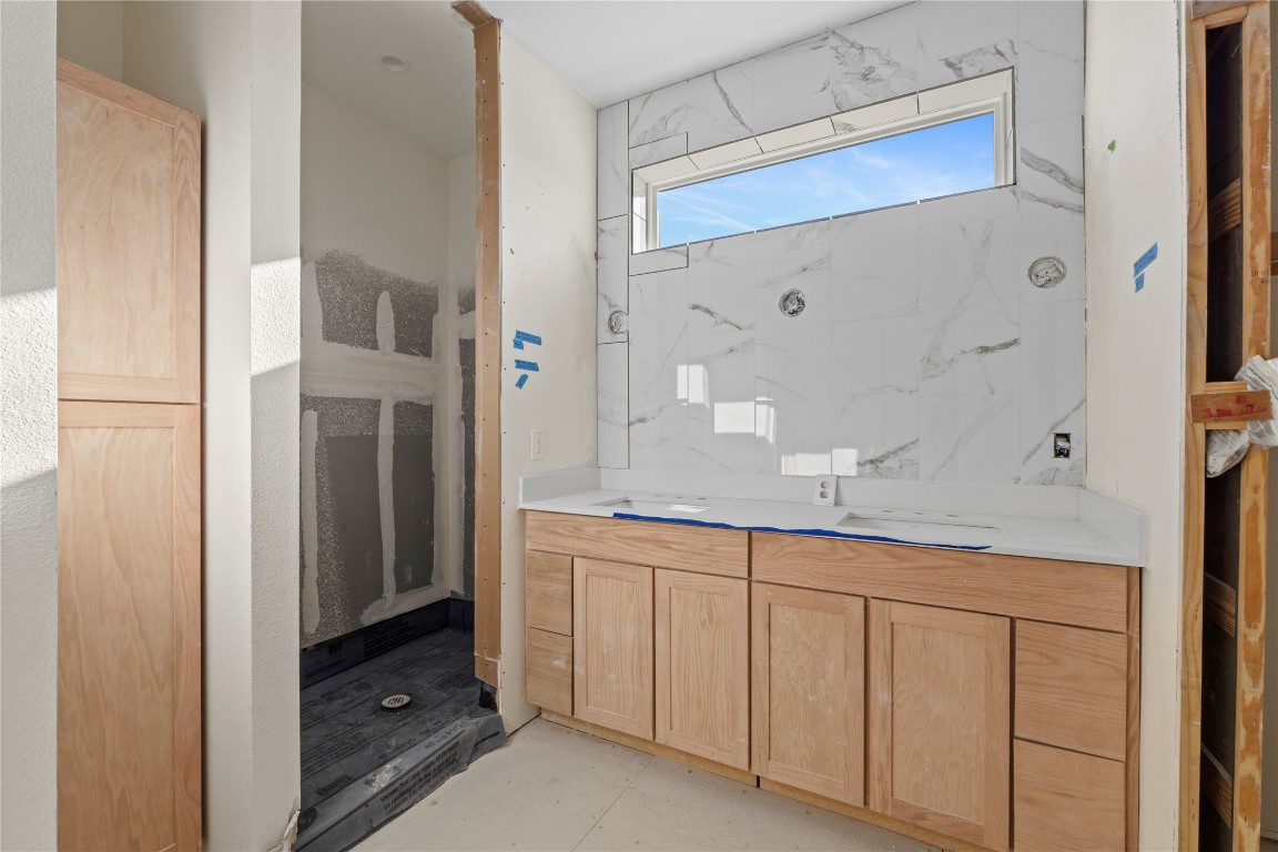 1180 Lott Avenue Austin, TX 78721 - Photo 15 of 40 a bathroom with a granite countertop sink a mirror and a shower