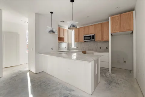 a kitchen with stainless steel appliances granite countertop a sink and a refrigerator