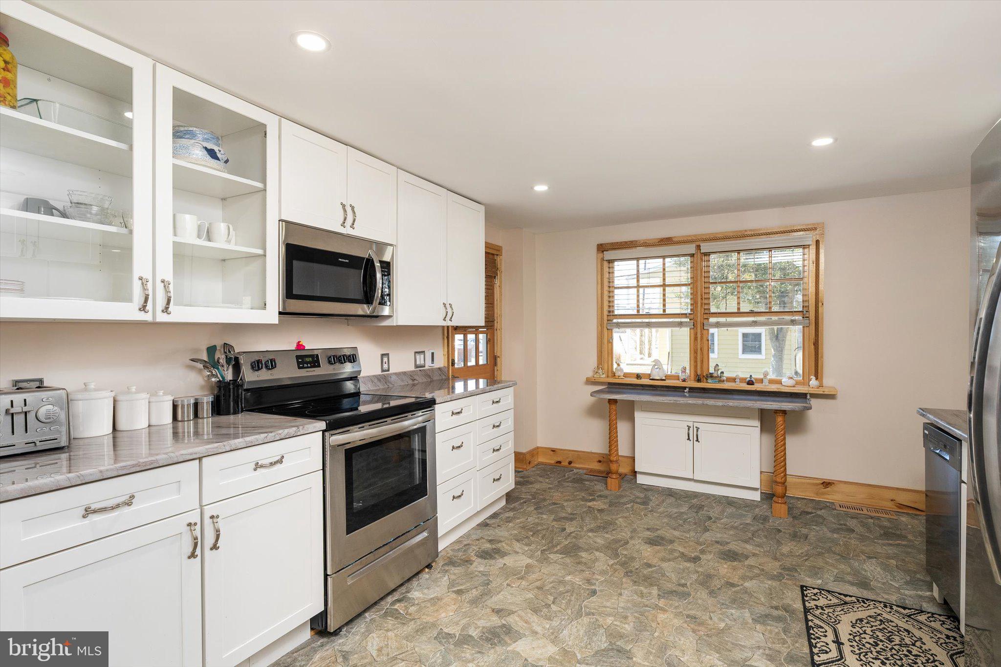 1387 Monmouth Road Mount Holly, NJ 08060 - Photo 12 of 31 a kitchen with stainless steel appliances a stove sink microwave and cabinets