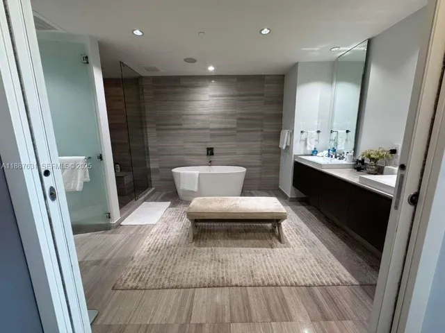 a spacious bedroom with a bed and a flat screen tv