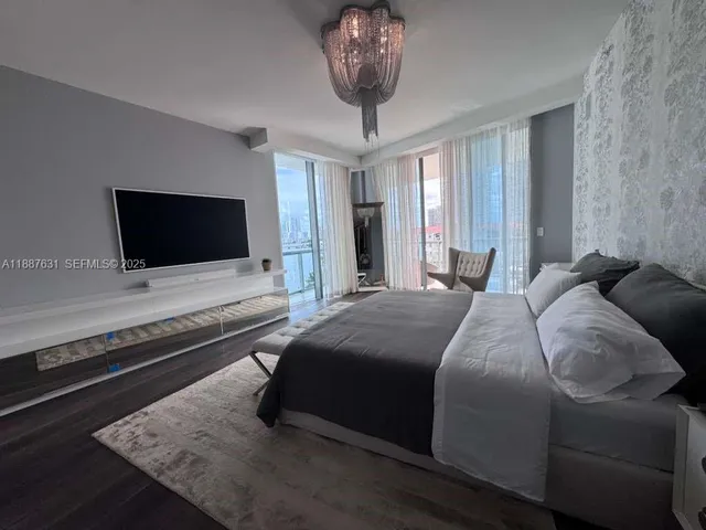 a bedroom with a bed and a chandelier