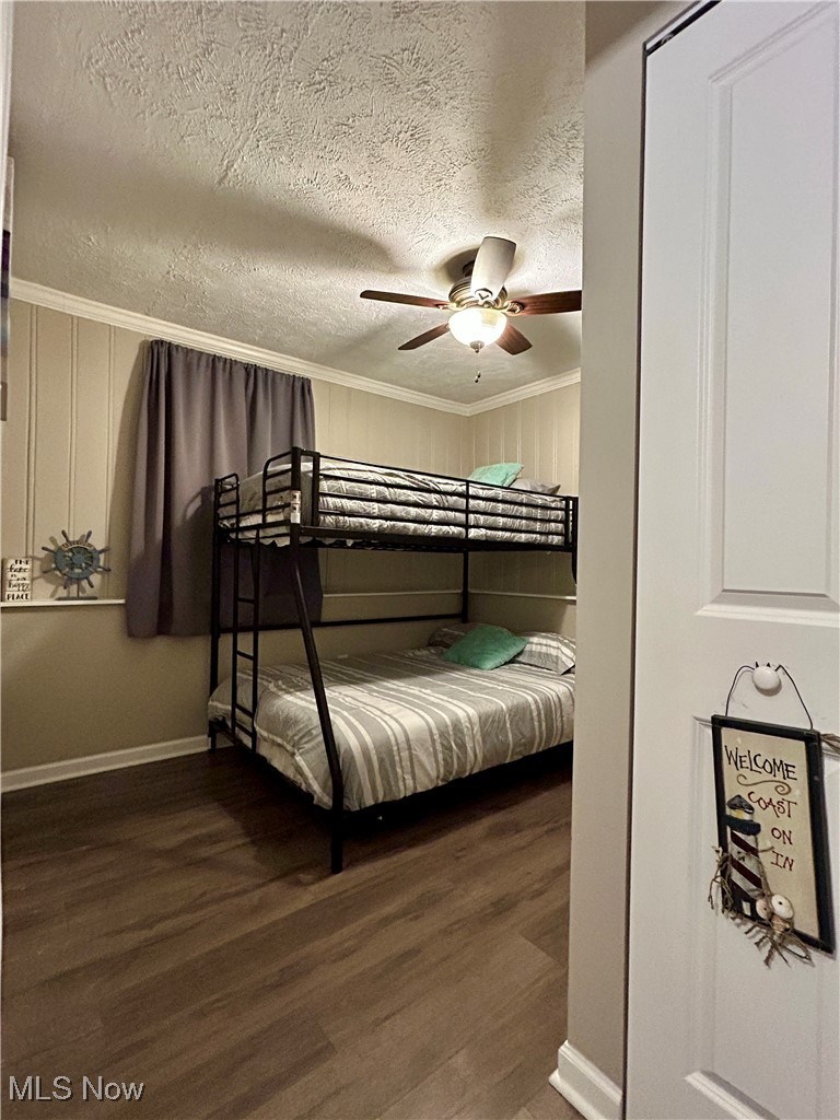 364 Erie Road Vermilion, OH 44089 - Photo 17 of 20 Bedroom with dark wood-type flooring, a textured ceiling, ceiling fan, and ornamental molding
