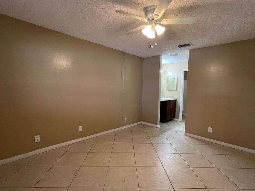 5249 Tennis Lane Delray Beach, FL 33484 - Photo 8 of 23 an empty room with closet and a ceiling fan