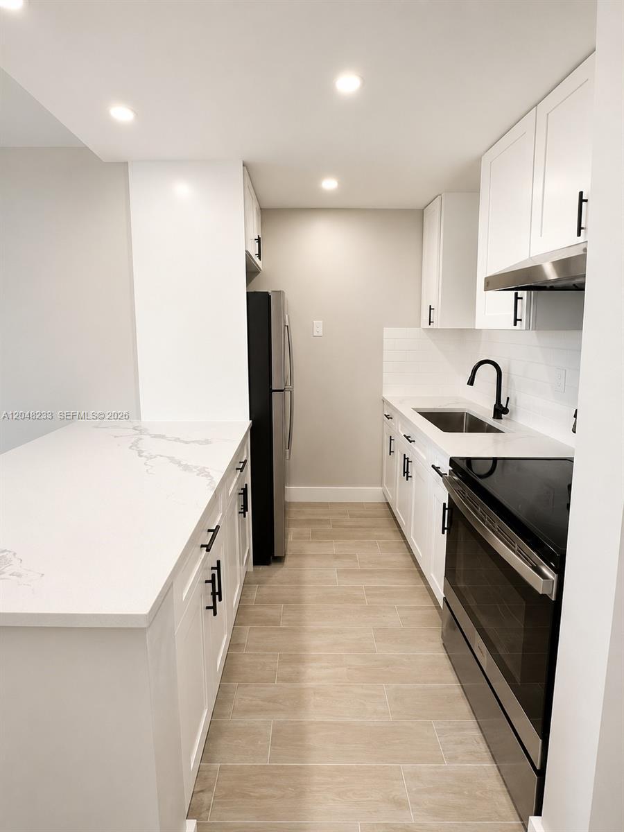 1530 Southwest 2nd Street, Unit 307 Miami, FL 33135 - Photo 2 of 7 a kitchen with granite countertop a sink and a stove