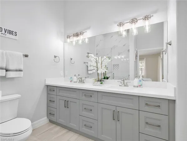 a bathroom with a granite countertop sink mirror and toilet