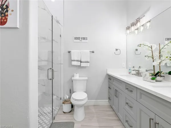 a spacious bathroom with a double vanity sink toilet and shower