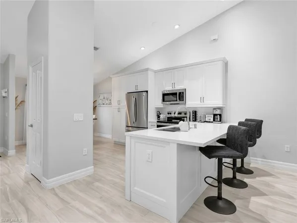 a living room with stainless steel appliances kitchen island granite countertop furniture and a hard wood floor